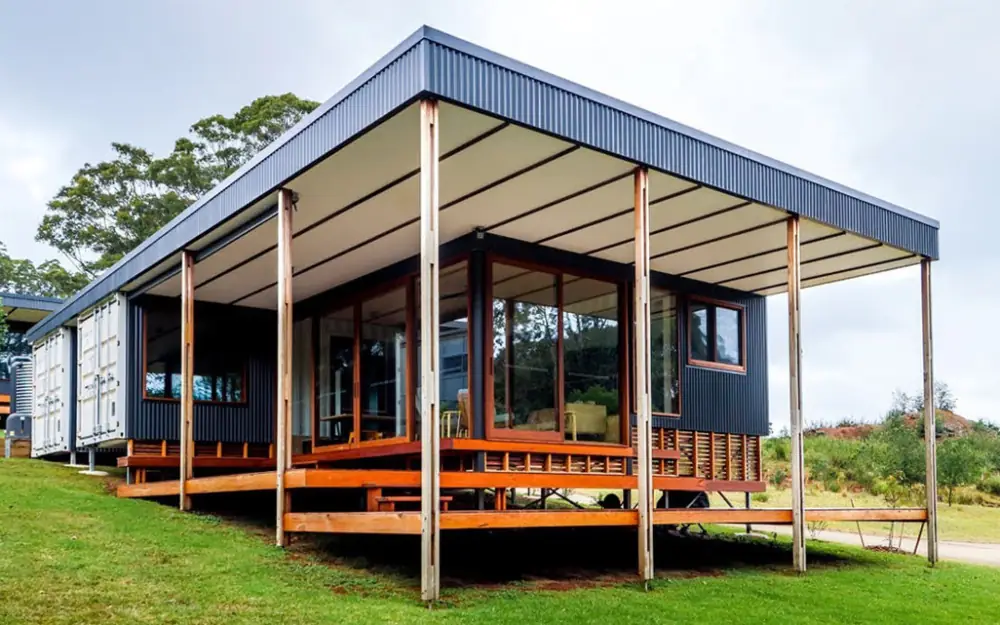 Container home with a wide covered terrace and timber deck