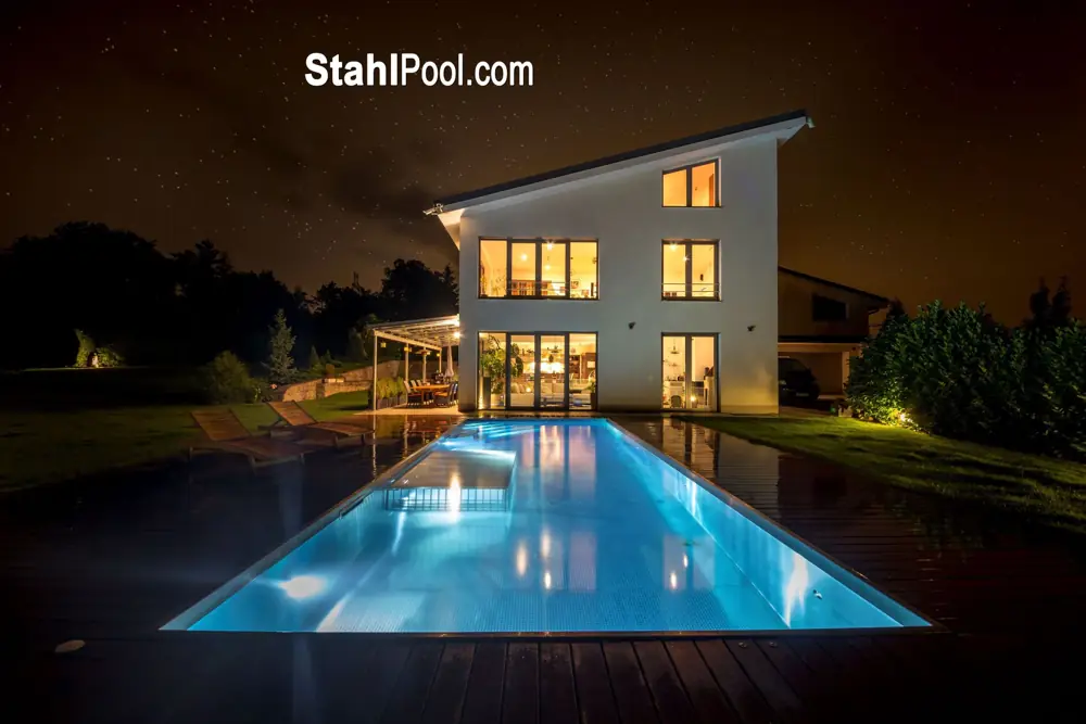 Beleuchtetes Haus mit Swimmingpool bei Nacht