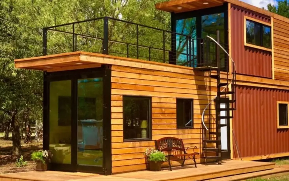 Timber-clad container home with an outdoor staircase to the roof terrace