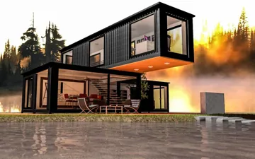 Schwarzes Containerhaus mit auskragendem Obergeschoss und Glasfront bei Sonnenuntergang