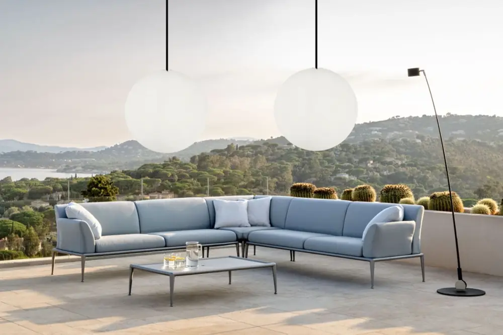 Outdoor-Sofa und große Kugel-Pendelleuchte vor Bergkulisse