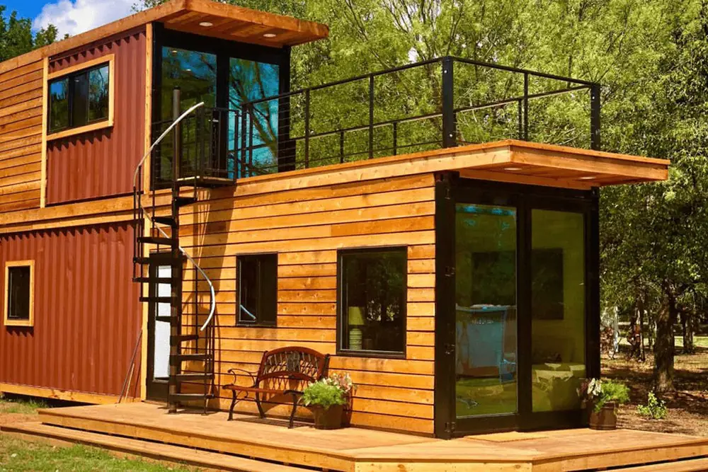 Small timber container home with a roof terrace and black outdoor staircase