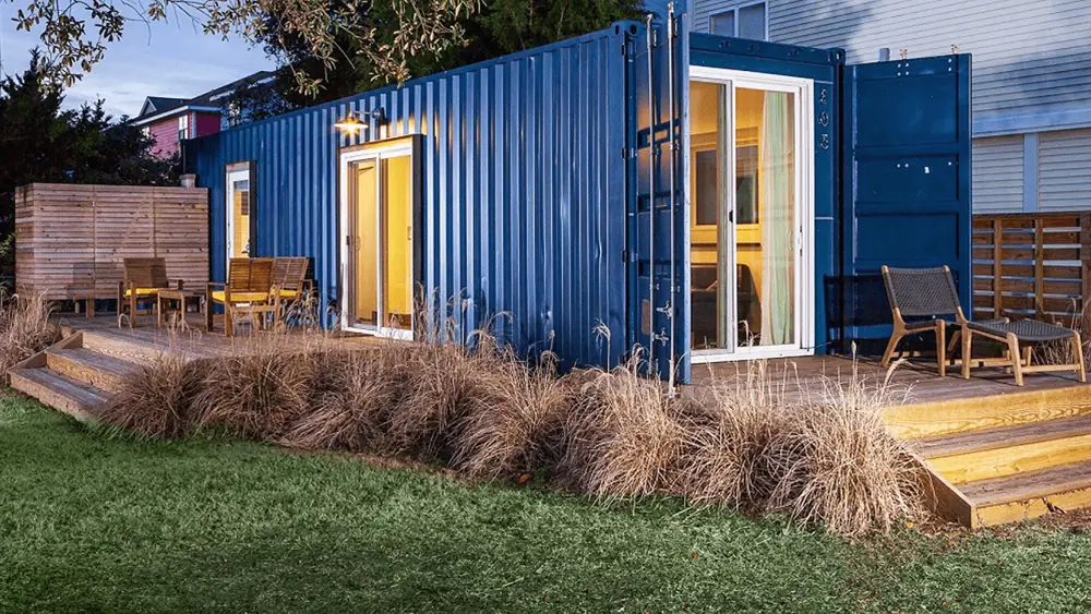 Blue garden living container with glass doors and a narrow timber terrace
