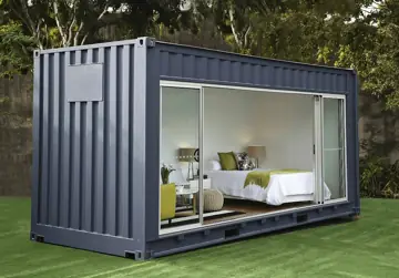 Grauer Mini-Container mit breiter Fensterfront und sichtbarem Schlafbereich