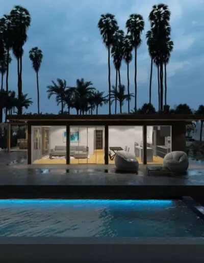 Illuminated living room behind glazing opposite a pool in the evening