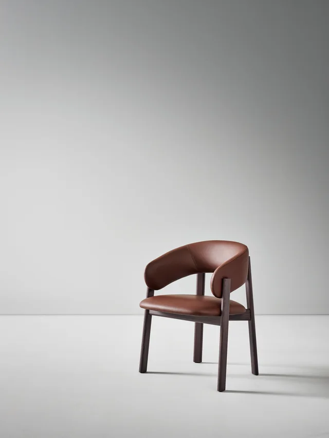 Bonaldo Alpha: Brown upholstered chair with a wrapping back and dark wooden frame · View 3