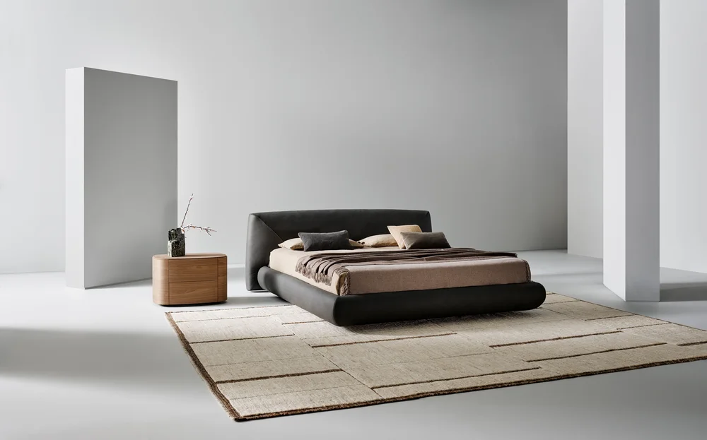 Bonaldo Holden: Dark upholstered bed with a low frame and angled headboard detail · View 1