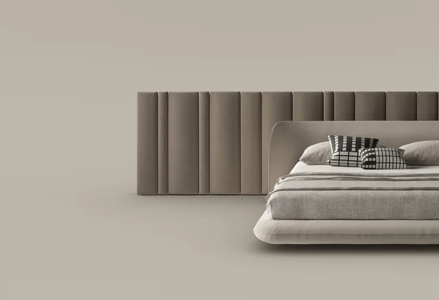 Bonaldo Nubo & Nubo boiserie: Helles gerundetes Bett vor breiter vertikal gegliederter Wandpolsterung · Ansicht 3