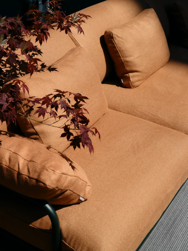 Fast Via Durini 2026: Street-side terrace with warm upholstery, plants and different table surfaces · View 7