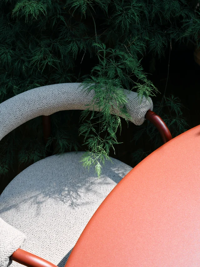 Fast Via Durini 2026: Street-side terrace with warm upholstery, plants and different table surfaces · View 8