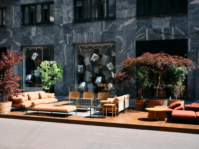 Fast Via Durini 2026: Street-side terrace with warm upholstery, plants and different table surfaces · View 14