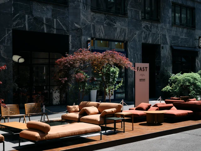 Fast Via Durini 2026: Street-side terrace with warm upholstery, plants and different table surfaces · View 17