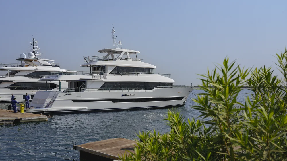 Gulf Craft Nomad 101: weiße Yacht mit langen Fensterbändern schwimmend am Liegeplatz