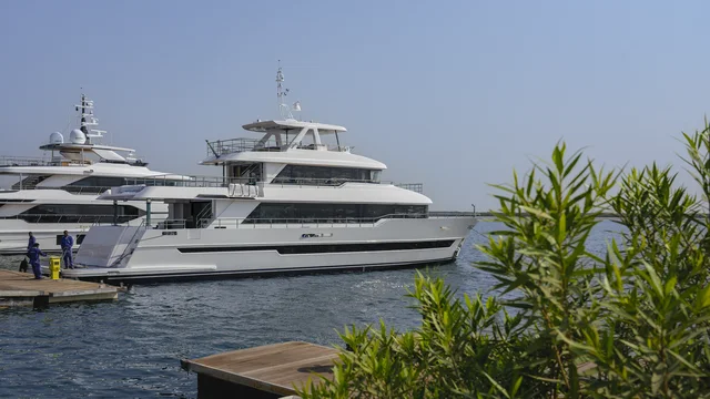 Gulf Craft Nomad 101: weiße Yacht mit langen Fensterbändern schwimmend am Liegeplatz