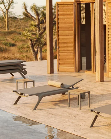VONDOM AFRICA: dunkle Liege mit gerundeter Kontur neben einem kleinen Tisch