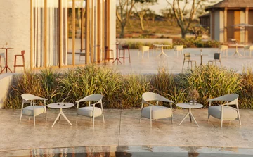 VONDOM AFRICA: three chairs and small round tables beside grasses and a glass façade