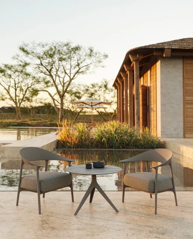 VONDOM AFRICA: zwei gepolsterte Stühle um einen runden Tisch an einer Holzfassade
