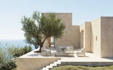 VONDOM GUM: helle Lounge-Gruppe auf erhöhtem Steinplateau mit Treppe und Blick zum Meer