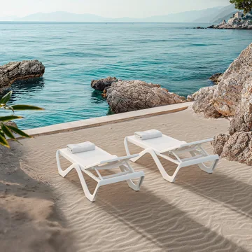 VONDOM LOVE: zwei weiße Liegen an einer sandigen Bucht mit türkisfarbenem Meer