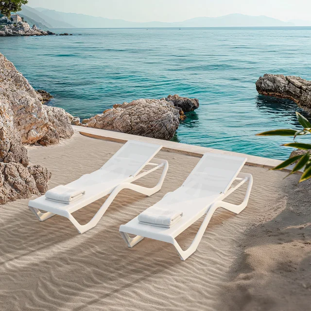 VONDOM LOVE: geschwungene weiße Sonnenliegen neben Felsen und Wasser