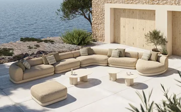 VONDOM MEL: große gerundete Sofagruppe mit mehreren Tischen an einer Steinhausterrasse