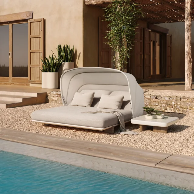 VONDOM MILOS: helles Daybed mit gerundetem Dach vor einer Glasfront am Wasser