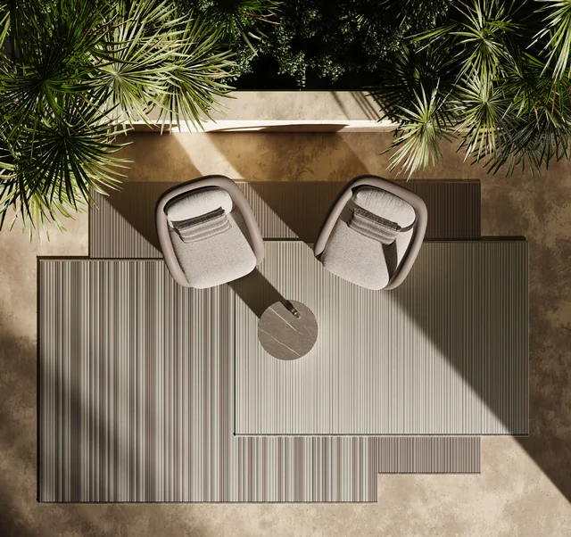 VONDOM outdoor rugs: overhead view of a striped rectangular rug with two armchairs and a small round table