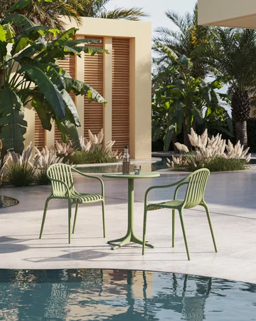 VONDOM PALM: green chairs around a pale table beside tropical planting
