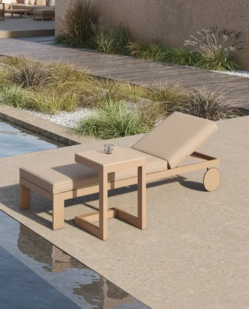 VONDOM POSIDONIA: Sonnenliege mit rundem Rad und eckigem Beistelltisch auf Steinplatten