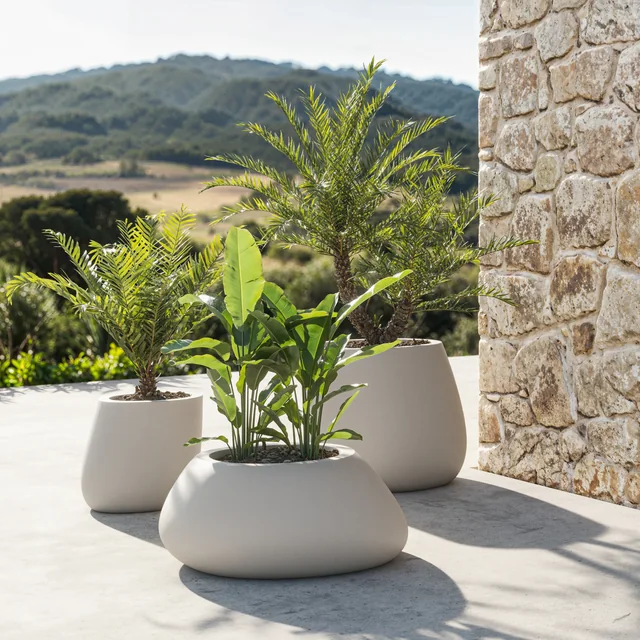 VONDOM STONE: unterschiedliche helle Pflanzgefäße mit grünen Pflanzen auf einer Terrasse